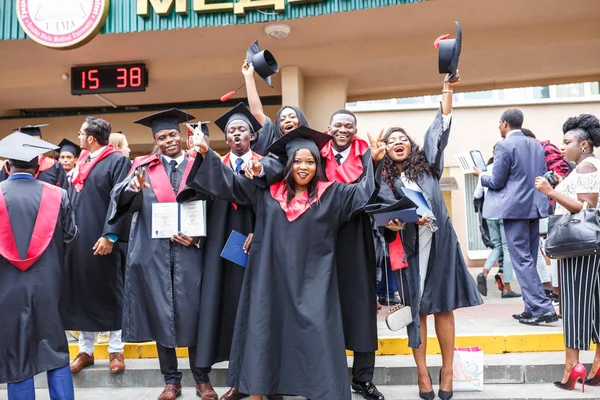 Grodno, Belarus - Haziran, 2018: Mutlu yabancı Afrika tıp öğrencileri kare akademik mezuniyet kapaklar ve bitirdikten sonra başlama diploms ile sırasında siyah trençkotlar çalışmalar