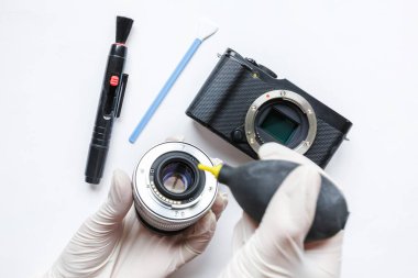 Close-up of mirrorless digital APS-C dirty camera matrix sensor cleaning and maintenance with swab, photographer cleaning photocamera on white background clipart