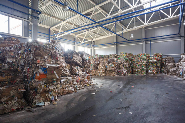 Plastic bales of rubbish at the waste treatment processing plant. Recycling separatee and storage of garbage for further disposal, trash sorting. Business for sorting and processing of waste.