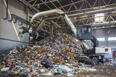 Grodno, Belarus - Mayıs 2018: Ekskavatör çöp atık işleme tesisi, birincil sıralama. Ayrı çöp toplama. Geri dönüşüm ve atık daha fazla bertarafı için depolama. 