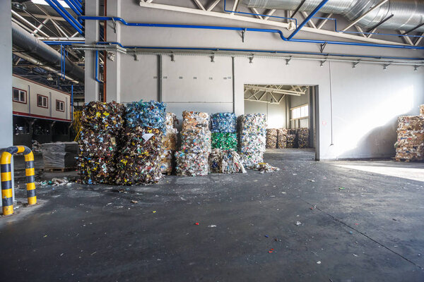 Plastic bales of rubbish at the waste treatment processing plant. Recycling separatee and storage of garbage for further disposal, trash sorting. Business for sorting and processing of waste.