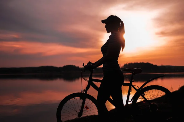 Летний Силуэт Пейзажа Девушка Велосипеде Озера Фоне Заходящего Солнца Багрового — стоковое фото