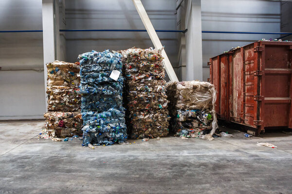 Plastic bales of rubbish at the waste treatment processing plant. Recycling separatee and storage of garbage for further disposal, trash sorting. Business for sorting and processing of waste.