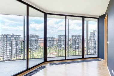 Parke zemin ve metropol şehir manzaralı panoramik pencerelere sahip modern beyaz boş loft daire iç