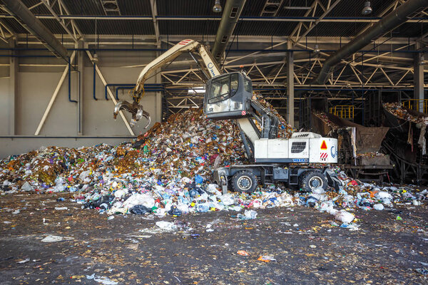 ГРОДНО, БЕЛАРУС - Май 2018: Экскаватор по первичной сортировке мусора на заводе по переработке отходов. Отдельная уборка мусора. Переработка и хранение отходов для дальнейшей утилизации
. 