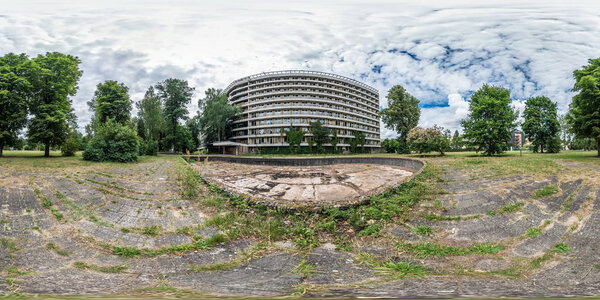 full seamless panorama 360 by 180 degrees angle view facade of  abandoned multi-storey, collapsing hotel near dry empty fountain in equirectangular spherical equidistant projection. VR AR content