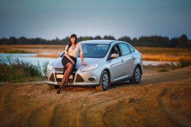 Genç mutlu güzel büyük boy modeli kız arabasını Sunset'teki yakınındaki