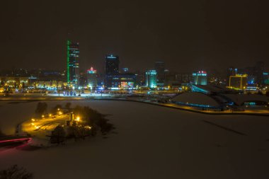 Minsk, Beyaz Rusya - Aralık 2018: gece şehrin ışıkları. Göl suya yansıyan ışık gökdelen