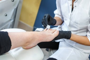 ana salonda siyah eldiven manikür pedikür yapan istemcinin kullanabileceği