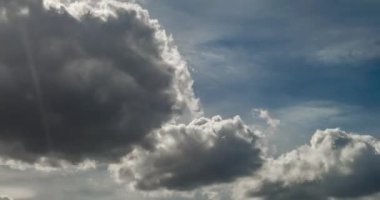 Zaman atlamalı küçük gri kabarık kıvırcık haddeleme bulutlar güneş ışınları ile rüzgarlı havalarda fırtına öncesi