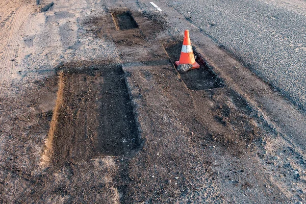 Cone de perigo de tráfego laranja branco na reparação de estradas de asfalto — Fotografia de Stock