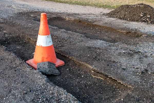 Cone de perigo de tráfego laranja branco na reparação de estradas de asfalto — Fotografia de Stock