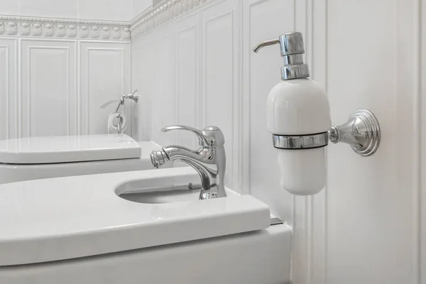 WC e dettaglio di un bidet doccia angolare con dispenser di sapone e shampoo su attacco doccia a parete — Foto Stock