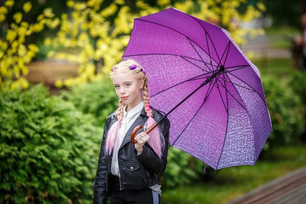 Крупним планом портрет маленької красивої стильної дівчинки з парасолькою під дощем на парку — стокове фото
