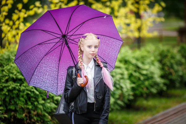 Close up portrait of little beautiful stylish kid girl with an umbrella in the rain on park — Stock Photo, Image