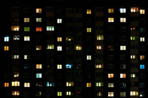 Νυχτερινή λήξη του Φωτός στα παράθυρα ενός πολυόροφου κτιρίου. ζωή σε μια μεγάλη πόλη — Φωτογραφία Αρχείου