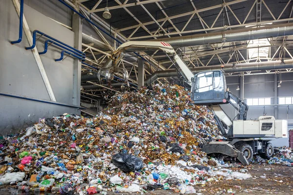 GRODNO, BELARUS - MAY 2018: Excavator on primary sorting of garbage at waste processing plant. Separate garbage collection. Recycling and storage of waste for further disposal. — Stock Photo, Image