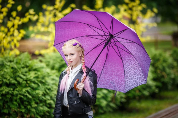Close up portrait of little beautiful stylish kid girl with an umbrella in the rain on park — Stock Photo, Image