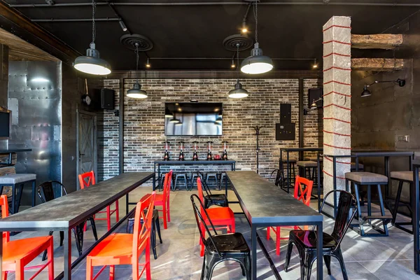 Grodno, Białoruś - marca, 2019: wewnątrz wnętrze w nowoczesny pub bar sportowy z ciemny strych styl z czerwone krzesła — Zdjęcie stockowe