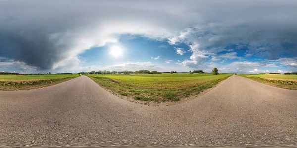 Πλήρης σφαιρική απρόσκοπτη πανόραμα 360 μοίρες θέα γωνία σε καμία οδική άσφαλτο δρόμο μεταξύ δρομάκι και χωράφια με φοβερά σύννεφα σε ισοορθογώνια ισομακρινή προβολή, περιεχόμενο VR AR — Φωτογραφία Αρχείου