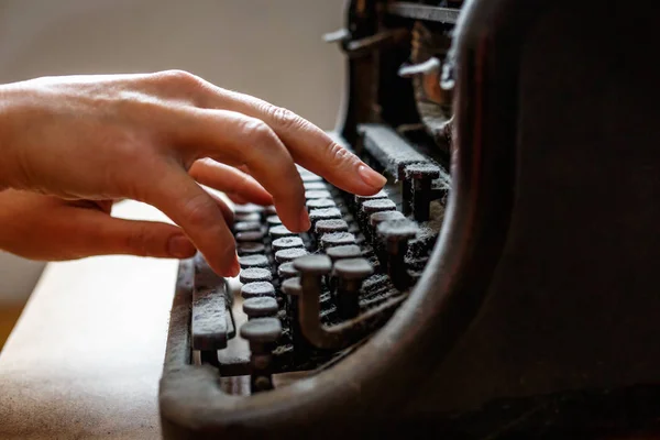 Donna mani tipo su una vecchia macchina da scrivere vintage ricoperta di polvere — Foto Stock