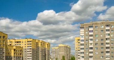Zaman atlamalı küçük sarı çok katlı apartmanlar arka planı beyaz kabarık haddeleme bulutlar