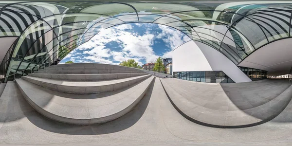 Panorama sferico completo angolo senza soluzione di continuità 360 gradi vicino alla facciata di un edificio moderno storto con enorme vetro specchiato in proiezione equirettangolare, contenuto VR AR — Foto Stock