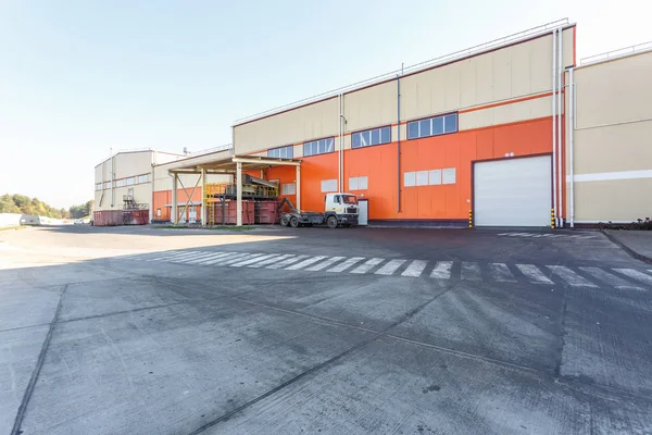 manufacture building of modern waste recycling processing plant in orange style. Separate garbage collection. Recycling and storage of waste for further disposal.