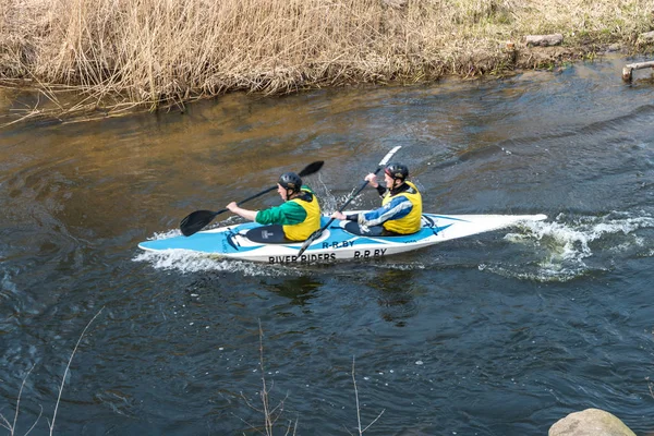 GRODNO, BÉLARO - ABRIL, 2019: competencia de kayak freestyle en el río de agua fría rápida remando vigorosamente, espíritu de victoria — Foto de Stock