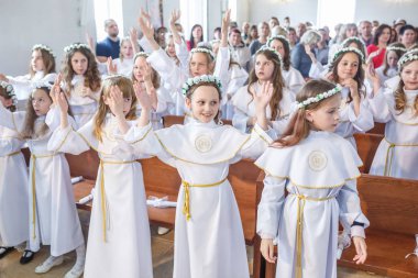 Grodno, Beyaz Rusya - Mayıs 2019: Katolik Kilisesi'ndeki küçük çocuklar ilk eucharist komünyonu bekliyor. Beyaz elbiseli küçük melekler