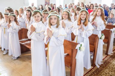 Grodno, Beyaz Rusya - Mayıs 2019: Katolik Kilisesi'ndeki küçük çocuklar ilk eucharist komünyonu bekliyor. Beyaz elbiseli küçük melekler