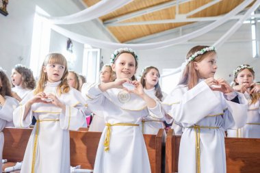 Grodno, Beyaz Rusya - Mayıs 2019: Katolik Kilisesi'ndeki küçük çocuklar ilk eucharist komünyonu bekliyor. Beyaz elbiseli küçük melekler