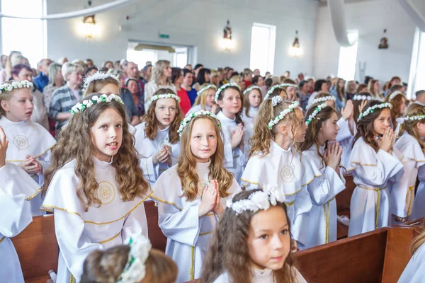 Grodno, Wit-Rusland-mei 2019: jonge kinderen in de katholieke kerk wachten op de eerste Eucharistie communie. Kleine engelen in witte kleren — Stockfoto