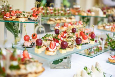 Catering. Saha dışında yemek. Çeşitli kanepeler, sandviçler, hamburgerler ve atıştırmalıklar içeren büfe masası. 