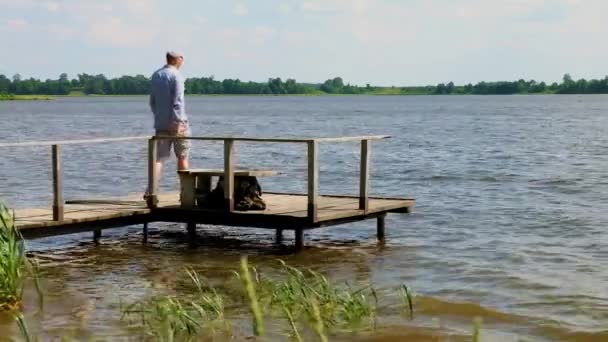 在大风天气里 男人在湖边的码头上散步和站立 — 图库视频影像