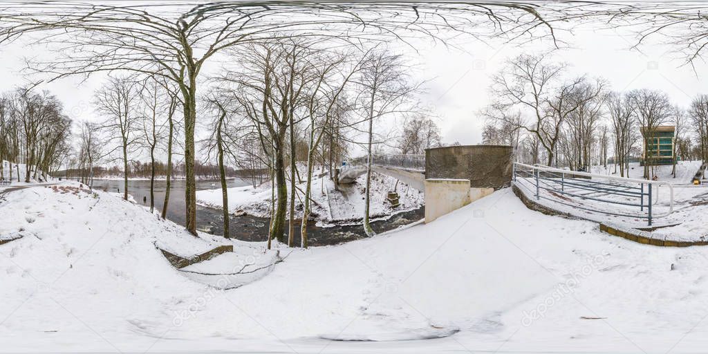 Winter full spherical seamless hdri panorama 360 degrees angle view in snowy park near the bridge of small river with gray pale sky  in equirectangular projection. VR AR content