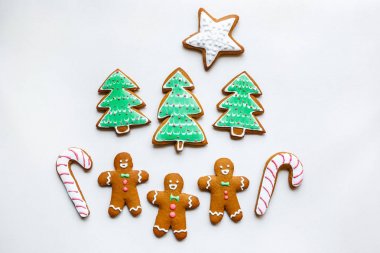Yıldız şeklinde el yapımı şenlikli zencefilli kurabiye, kar taneleri, insanlar, çorap, personel, eldivenler, Noel ağaçları, xmas ve beyaz kağıt arka plan üzerinde yeni yıl tatili için kalpler