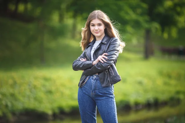 Porträtt av lite vacker snygg unge flicka i stads parken på grön skogs bakgrund — Stockfoto