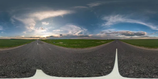 Panorama sphérique sans couture hdri 360 degrés vue d'angle sur route asphaltée parmi les champs en été coucher de soleil du soir avec des nuages impressionnants en projection équirectangulaire, prêt VR AR contenu de réalité virtuelle — Photo