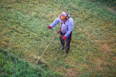 Çim biçme makinesi ile kuru çim kesme üst görünümü çim man işçi.