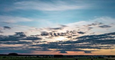 Rüzgarlı havalarda akşam kabarık kıvırcık haddeleme altostratus bulutlar ile gün batımı 4k Time lapse klip 