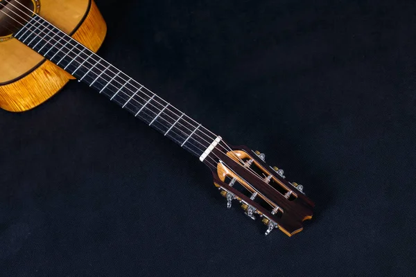 黒の背景に6弦アコースティックギターネックの木製マシンヘッドにペグをチューニング — ストック写真