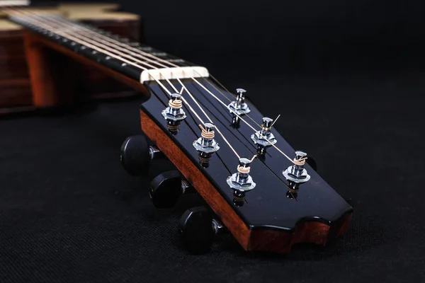 Pinzas de afinación en cabezal de máquina de madera de seis cuerdas cuello de guitarra acústica sobre fondo negro —  Fotos de Stock