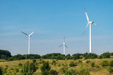 Mavi arka planda dönen yel değirmeni pervanesi. Rüzgar enerjisi üretimi. Saf yeşil enerji.