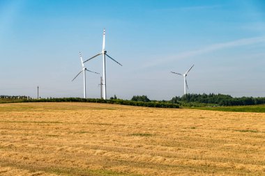 Mavi arka planda dönen yel değirmeni pervanesi. Rüzgar enerjisi üretimi. Saf yeşil enerji.