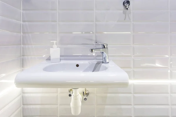 Distributori di sapone e shampoo vicino al lavandino del rubinetto dell'acqua di ceramica con rubinetto in costoso bagno soppalco — Foto Stock