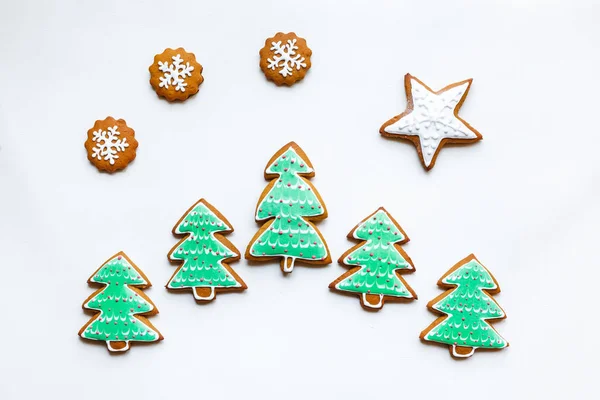 Biscoitos de gengibre festivos feitos à mão na forma de estrelas, flocos de neve, pessoas, meias, pessoal, luvas, árvores de Natal, corações para xmas e feriado de ano novo no fundo do livro branco — Fotografia de Stock