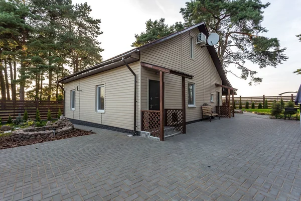 Moderna casa de campo ecológica en un bosque de pinos al atardecer — Foto de Stock