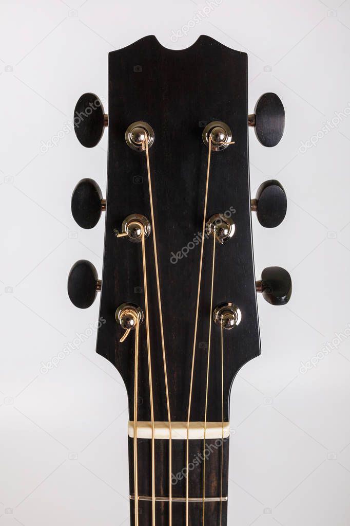 Tuning pegs on wooden machine head of six strings guitar on white background