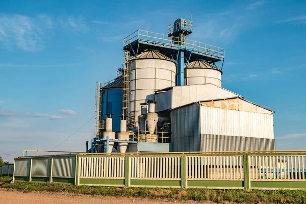 Perak silo pada pabrik pengolahan pertanian untuk pengolahan pengeringan dan penyimpanan produk pertanian, tepung, sereal dan biji-bijian dengan awan yang indah — Stok Foto